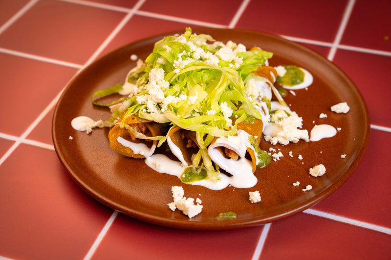 Flautas con lechuga, crema y queso fresco