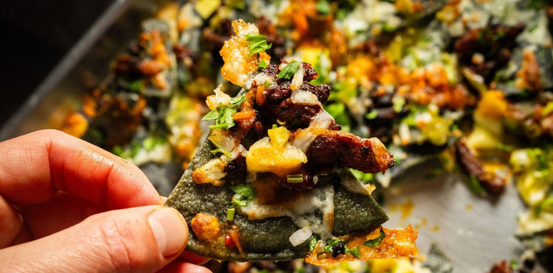 Nachos al Pastor con totopos de tortilla azul recién fritos