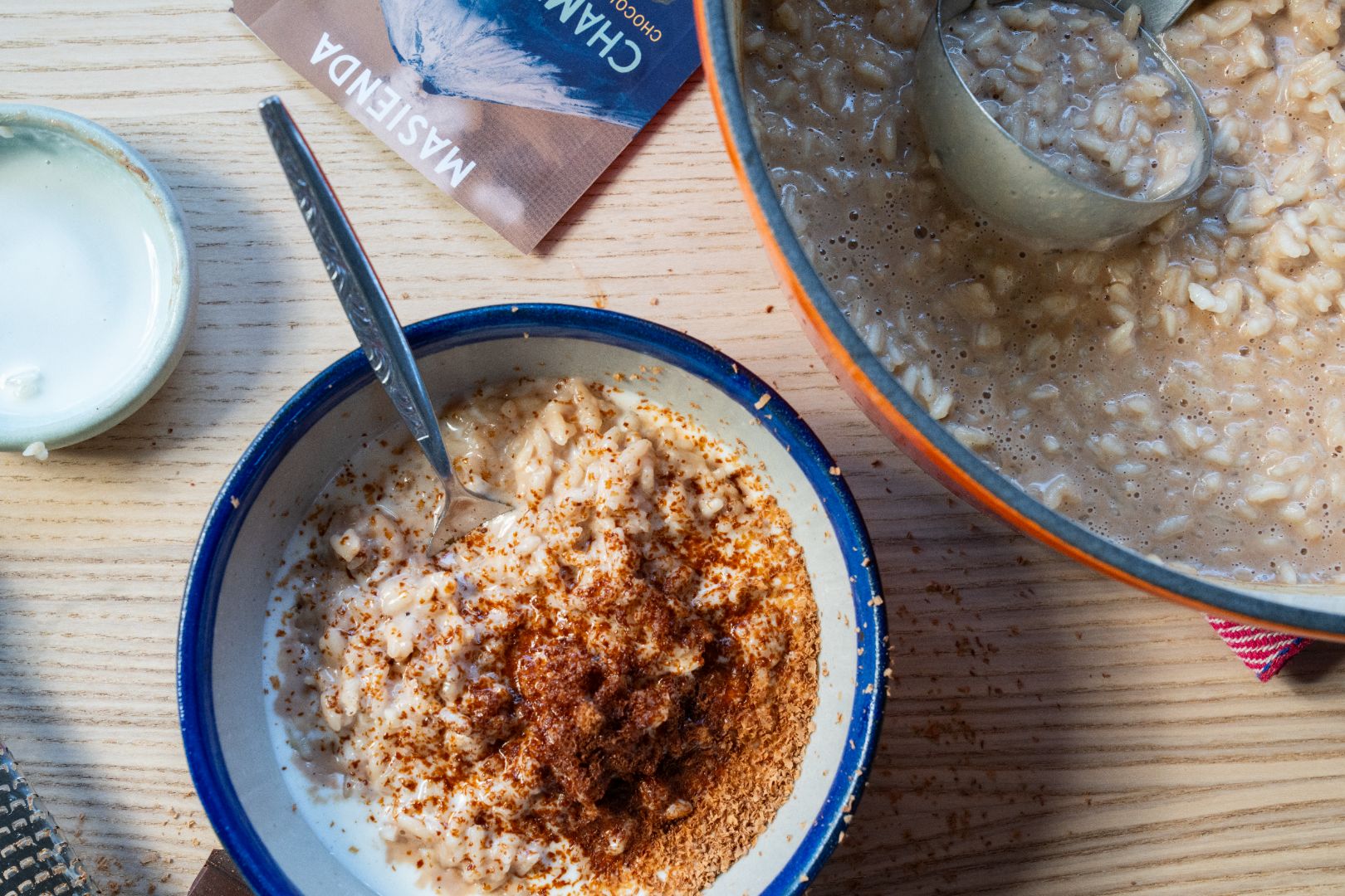 Tazón de Arroz con Leche con Champurrado adornado con mezcla de champurrado y crema dulce