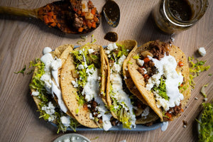 Plato de tacos de picadillos con lechuga, crema agria, queso fresco y salsa