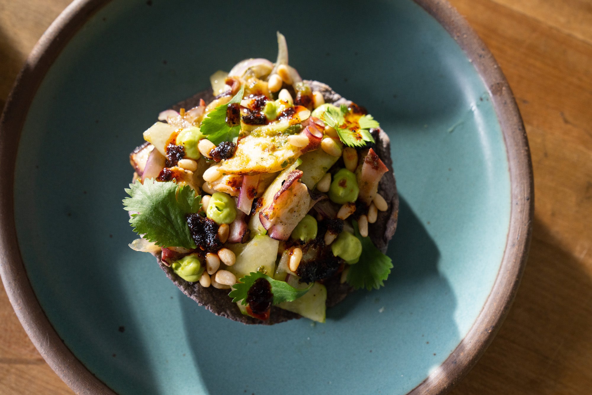 Una tostada con aguachiles de pulpo