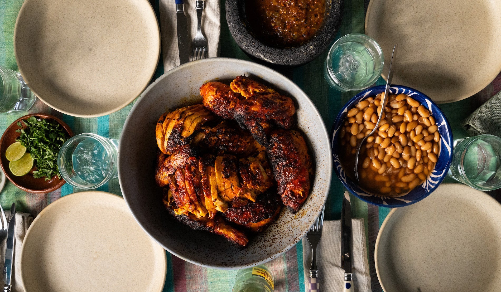 Bowl of pollo al carbon on table with beans and salsa