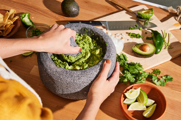 Guacamole con tostadas, servido en molcajete de Masienda