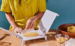 White masa harina being pressed on a tortilla kit