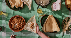 Tamalada set up - A table of corn husks being filled with chicken filling