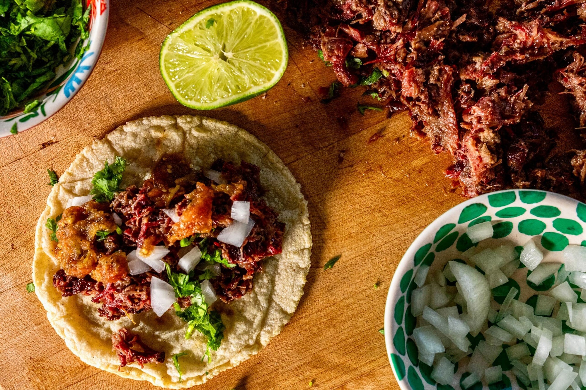 Taco de barbacoa topped with cilantro and onion