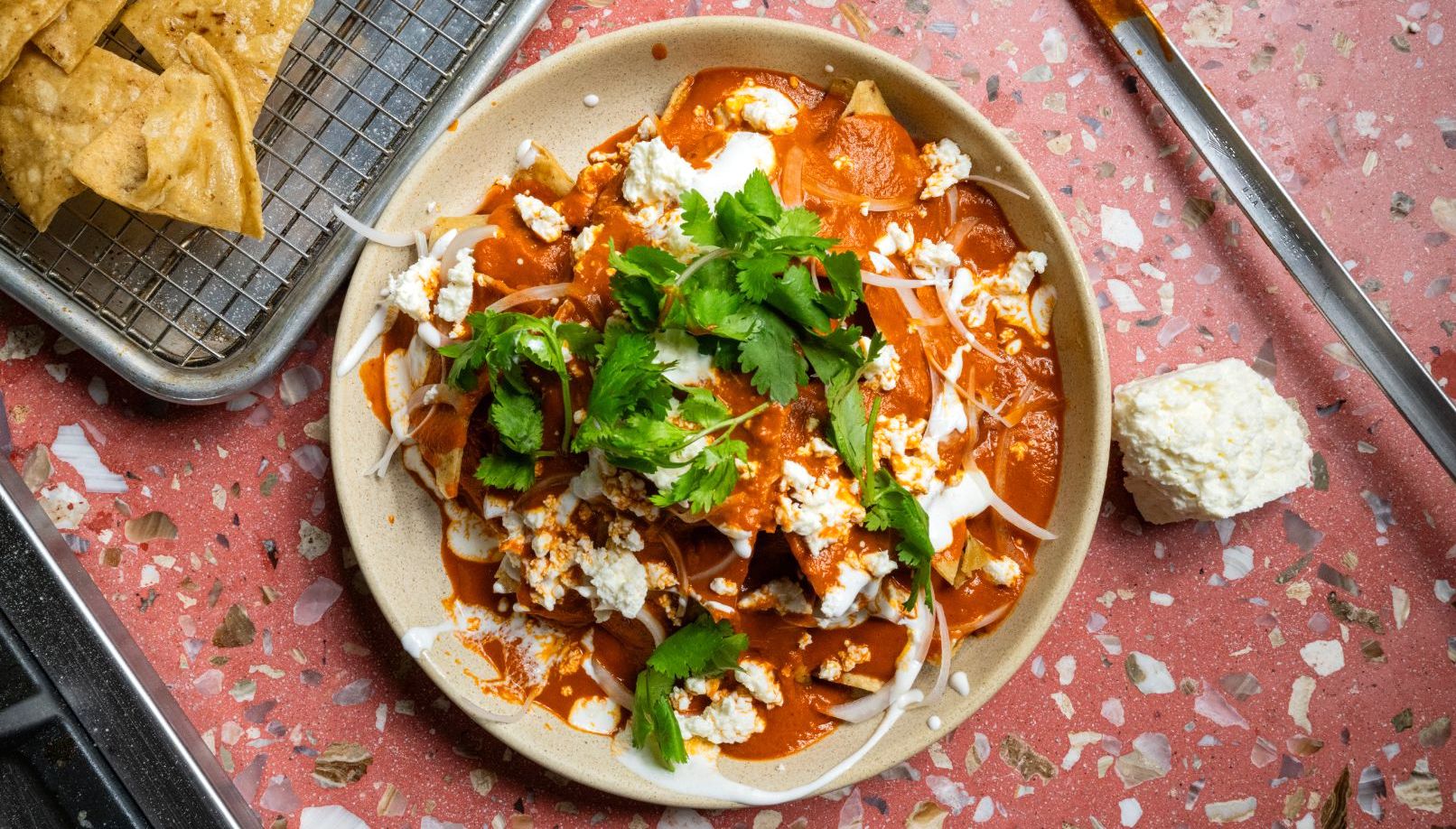 Chilaquiles rojos topped with crema, queso fresco, and cilantro