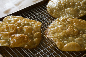 Freshly made buñuelos on a heating rack