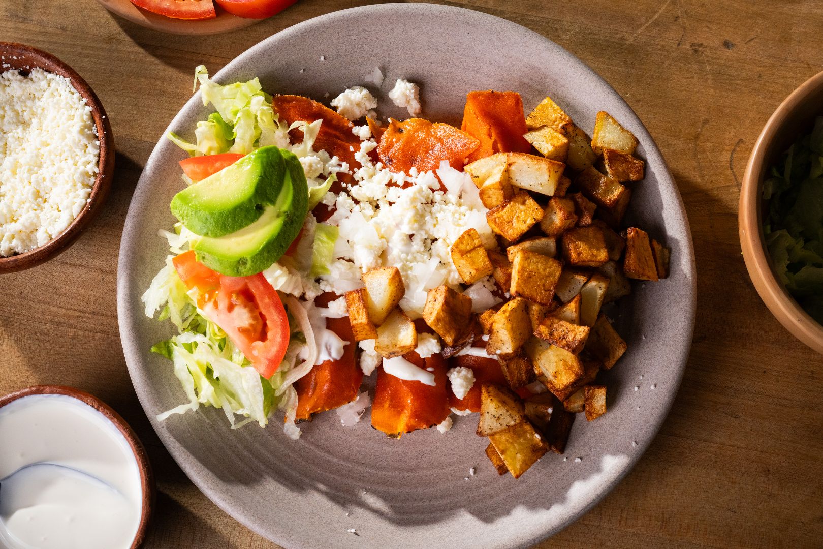 Plate of enchiladas de queso topped with crema and queso