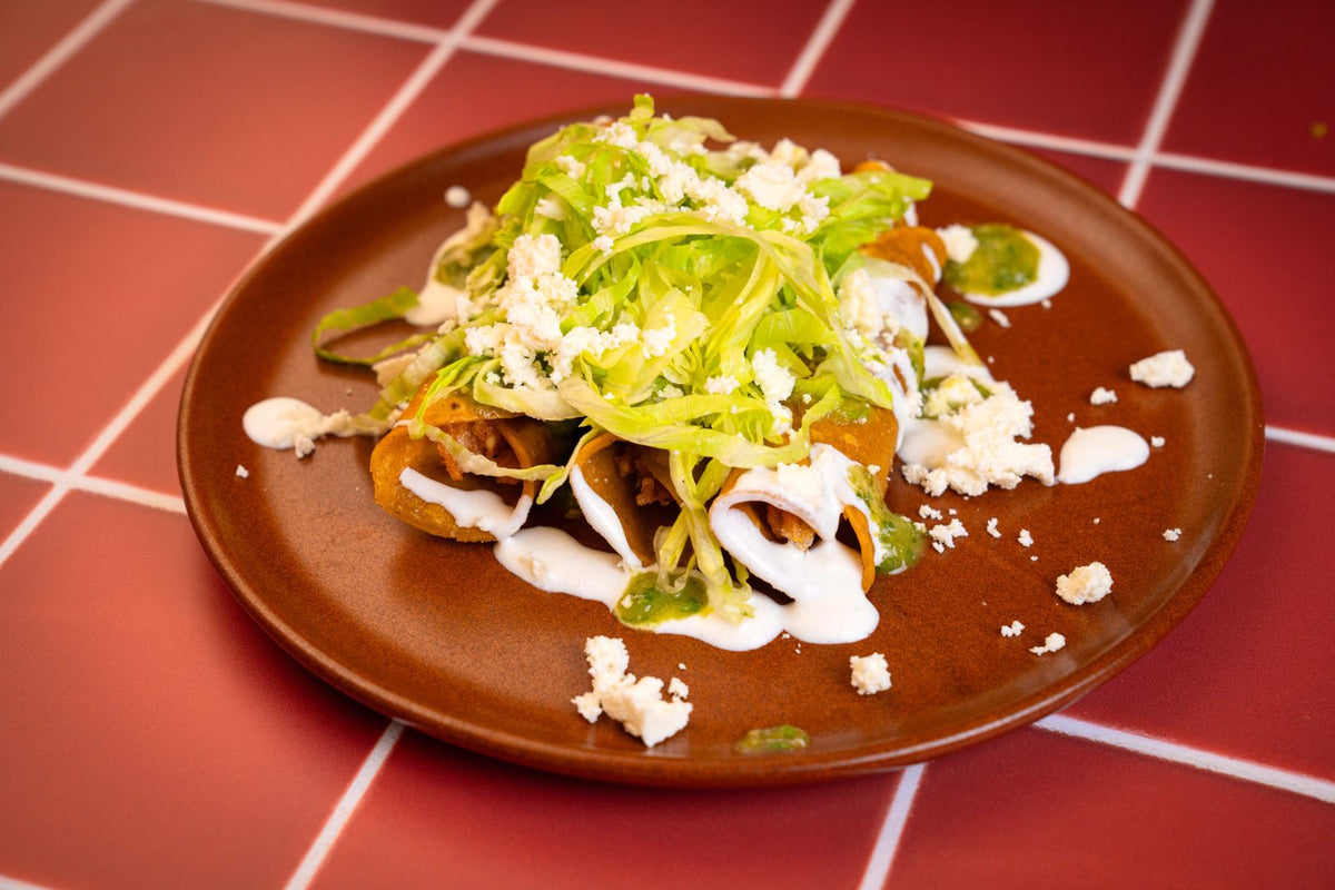 Flautas con lechuga, crema y queso fresco