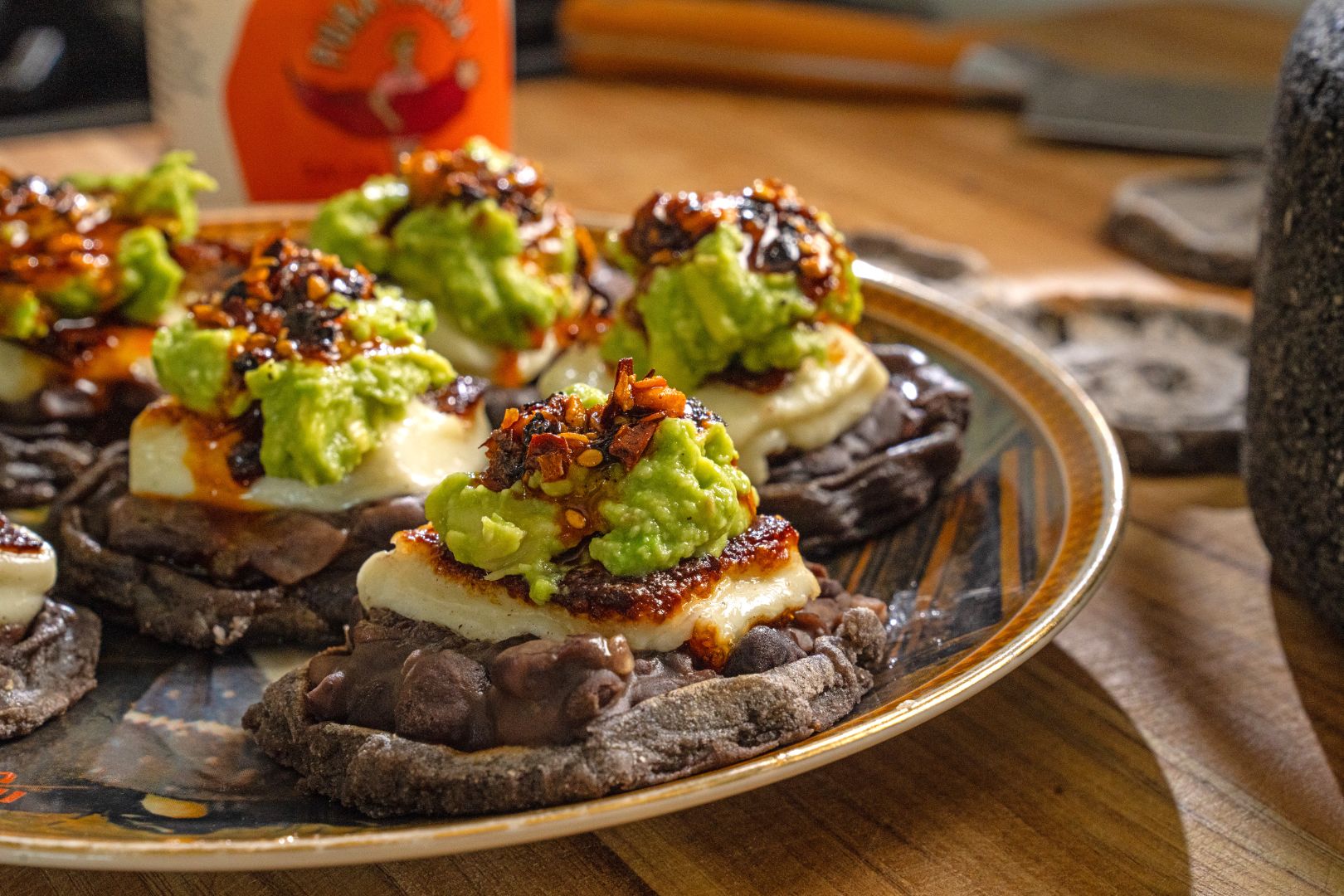 Mini black bean sopes with panela cheese, avocado, and salsa macha