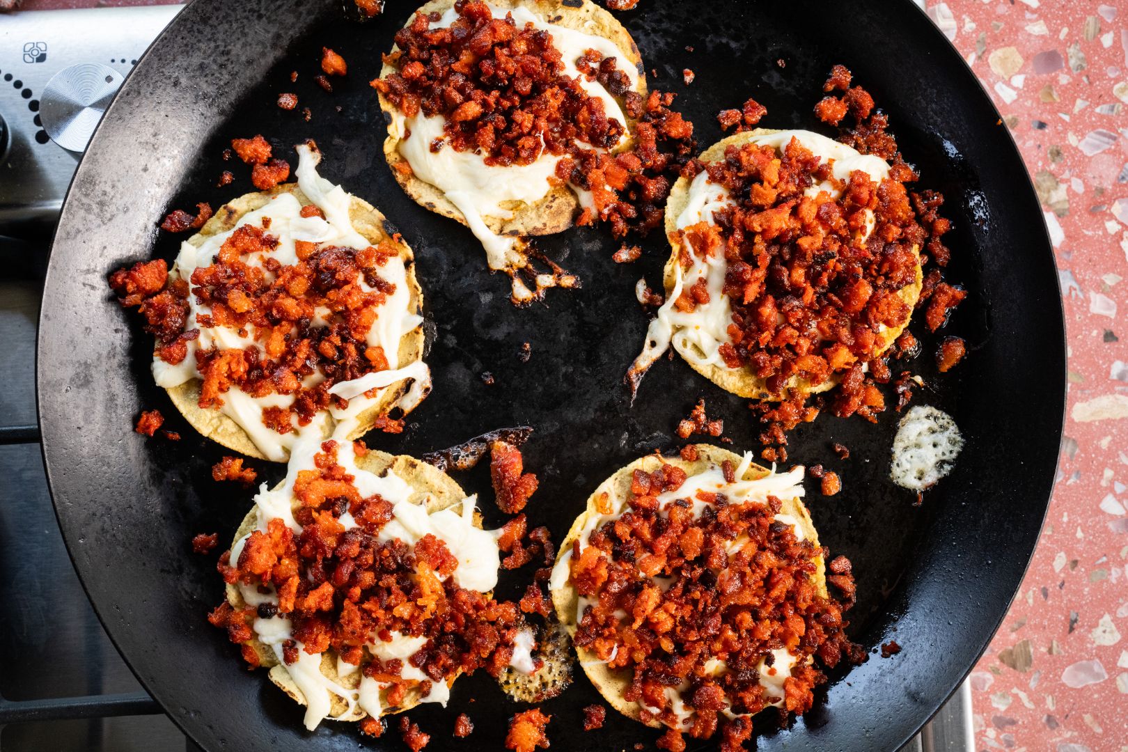 Volcanes on a comal topped with quesillo, chorizo, and guacamole