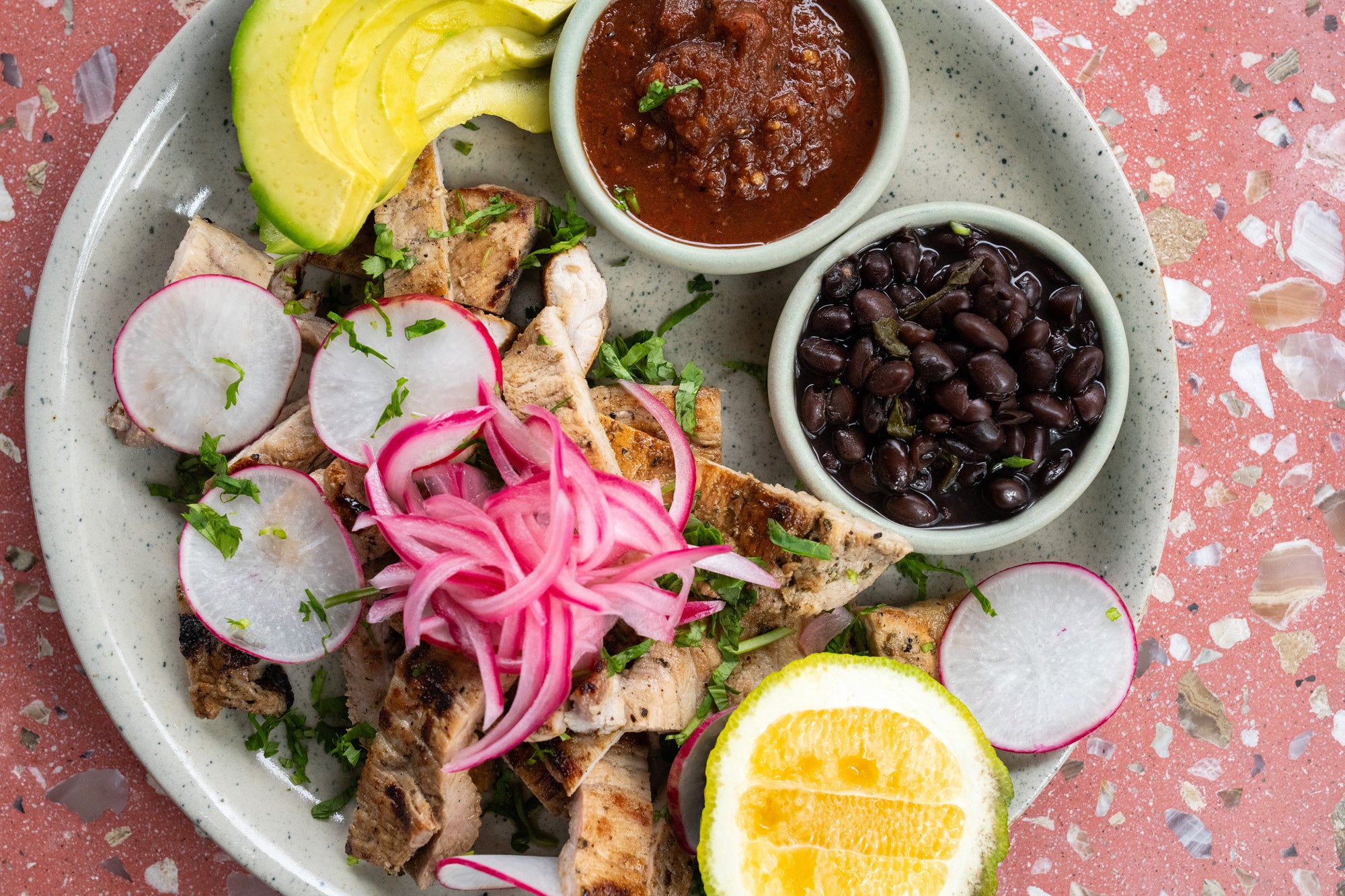 Poc Chuc topped with pickled red onions and radishes