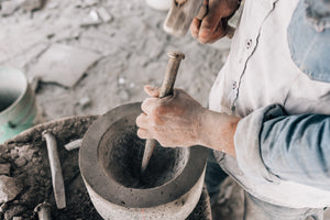 Molcajete being sculpted with chisel and pick
