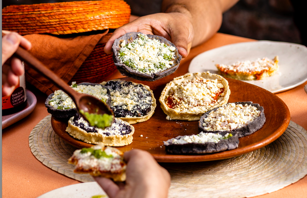 Un plato de sopes cubierto con salsa